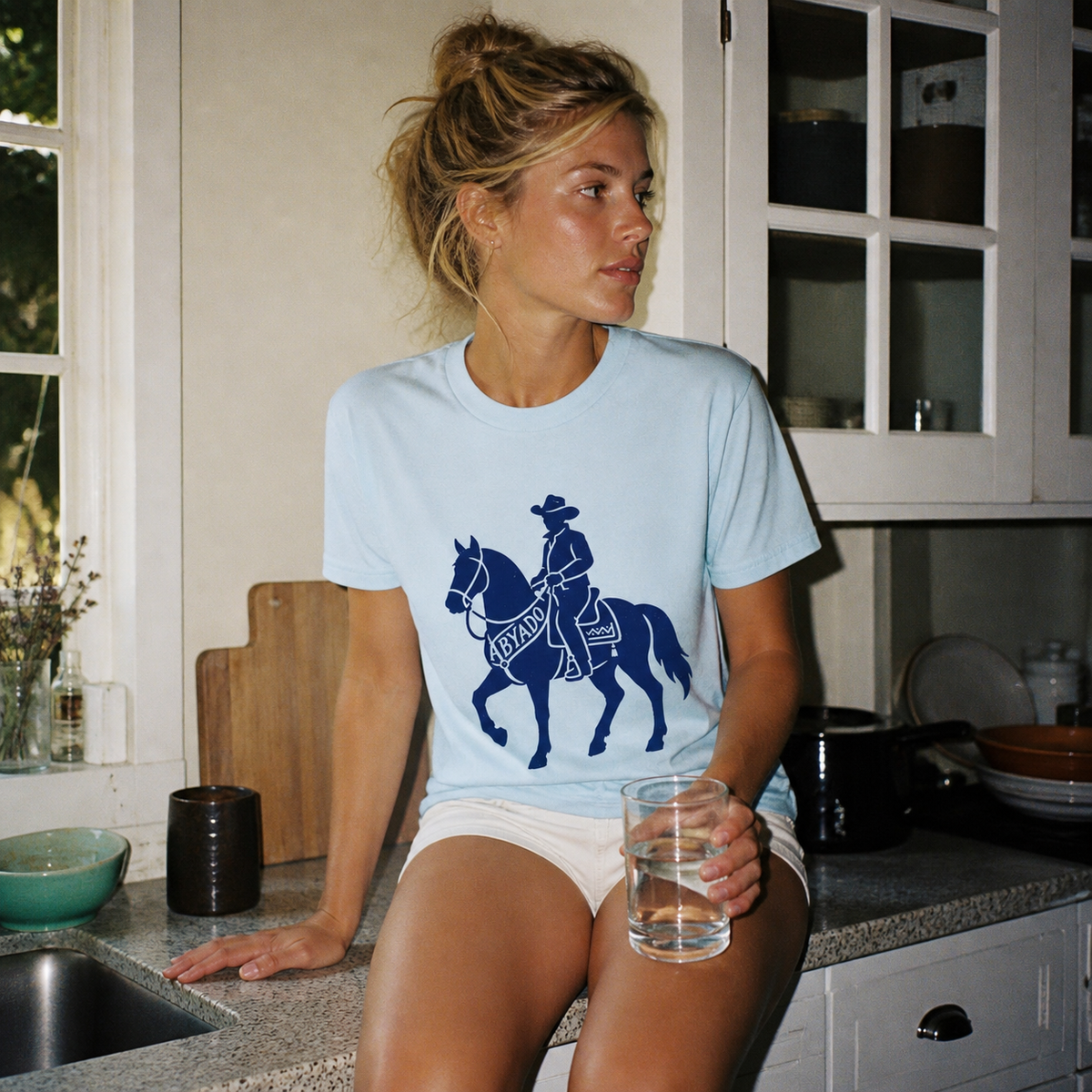 Marston Tee lifestyle — Light Blue front graphic — kitchen 1:1