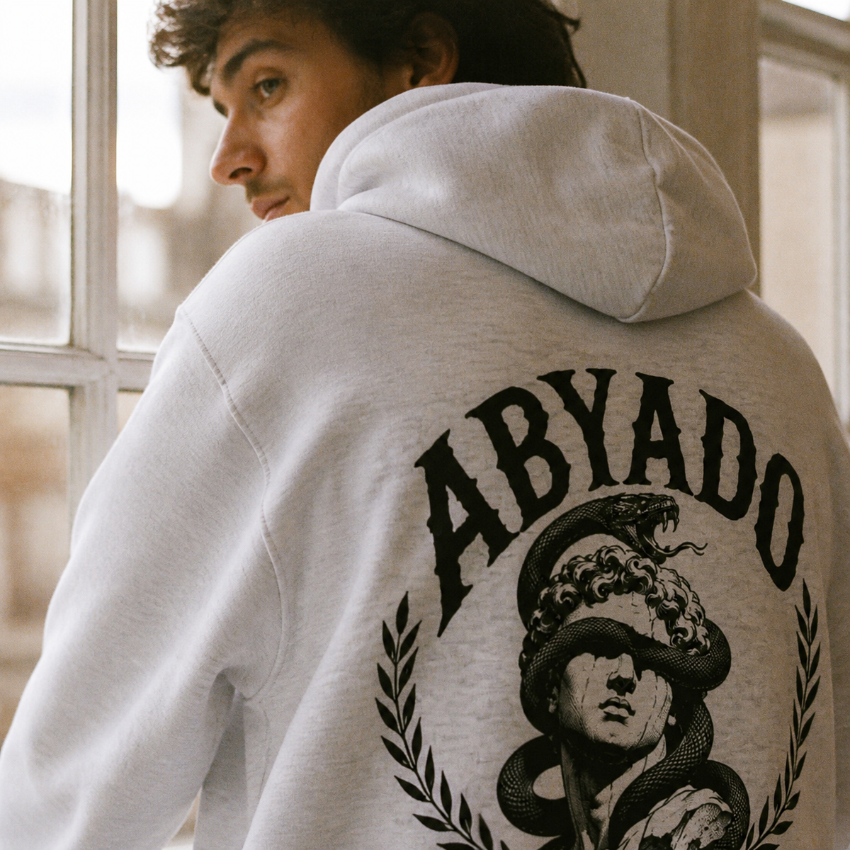 Relics Hoodie in White Heather, close-up of back graphic and hood, film lifestyle photograph